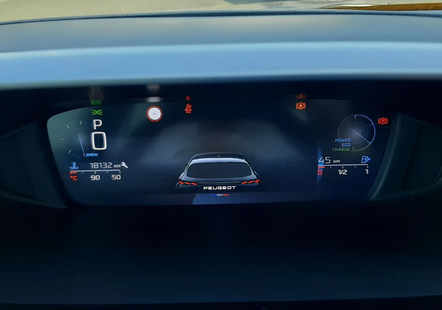 Tableau de bord numérique de la Peugeot 308 III Hybrid 145ch Style, affichant la vitesse à 0 km/h et l'autonomie hybride.