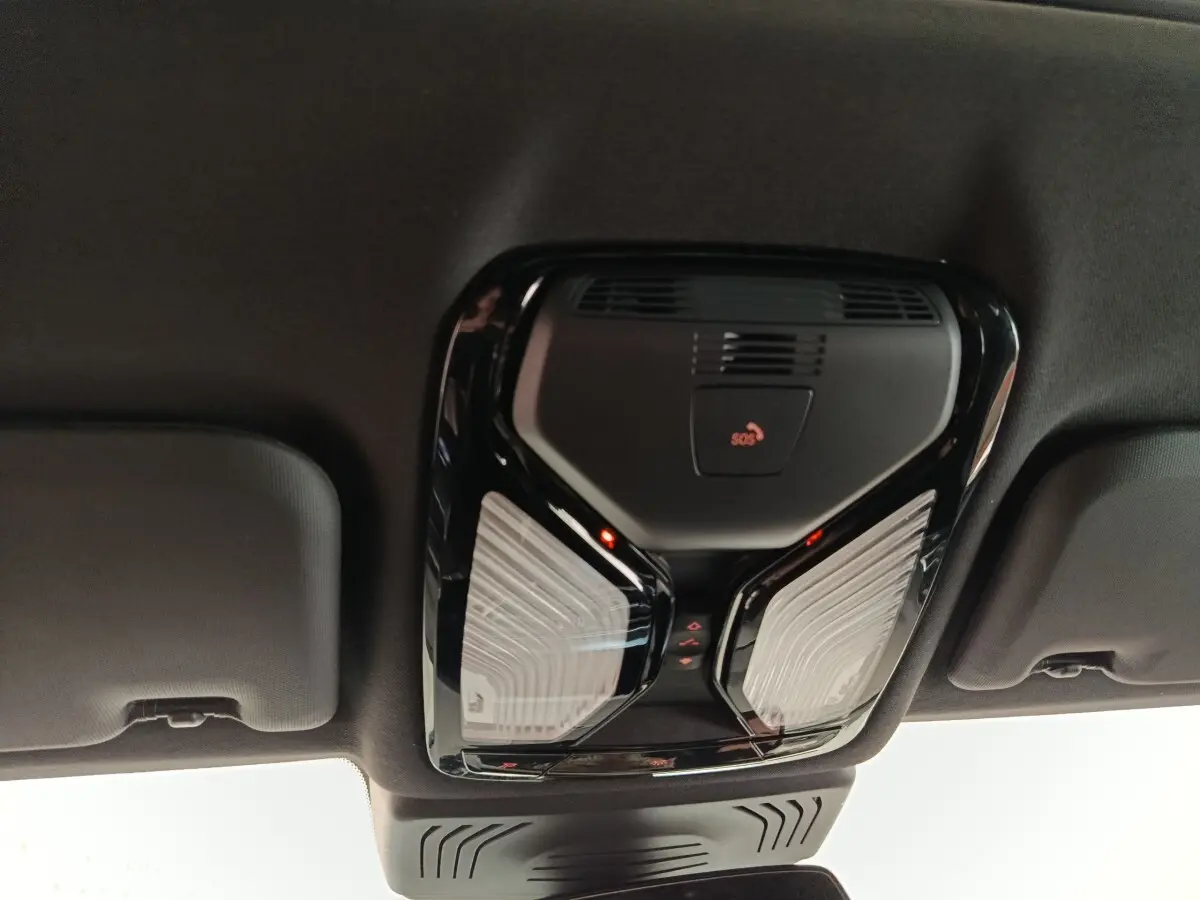 Plafonnier intérieur noir avec bouton SOS et éclairage LED, vue du toit d’un BMW X3 blanc hybride rechargeable.