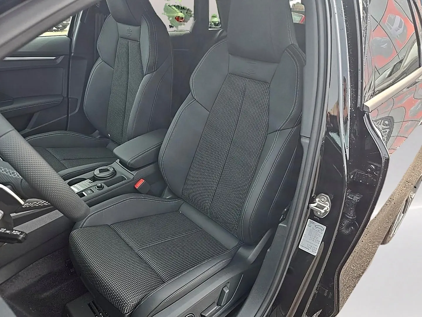 Vue intérieure côté conducteur de l’Audi A3 Sportback 2026 noir mythos avec sièges sport S line en cuir et tissu.