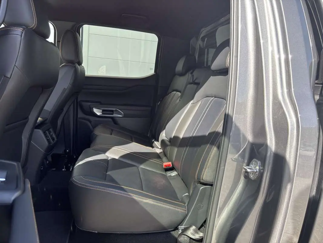 Vue intérieure côté droit sur la banquette arrière en cuir noir avec surpiqûres contrastantes du Ford Ranger gris carbone.