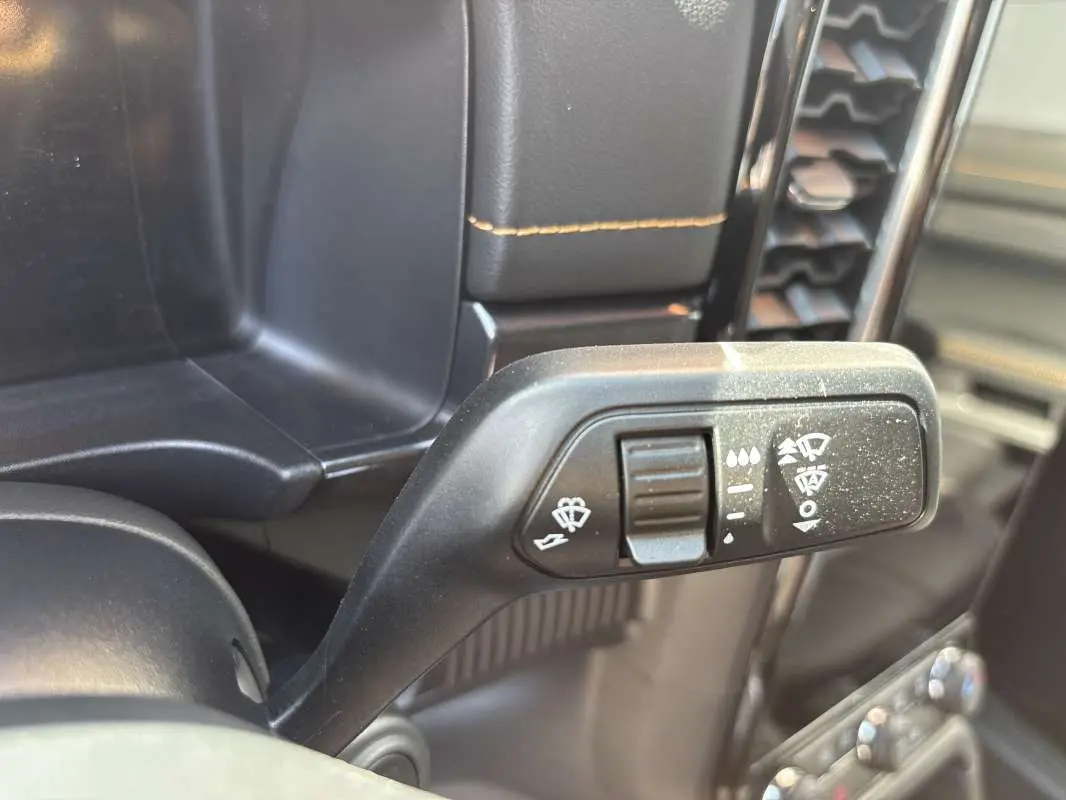 Gros plan sur la commande des essuie-glaces du Ford Ranger gris carbone, intérieur avec coutures jaunes visibles.