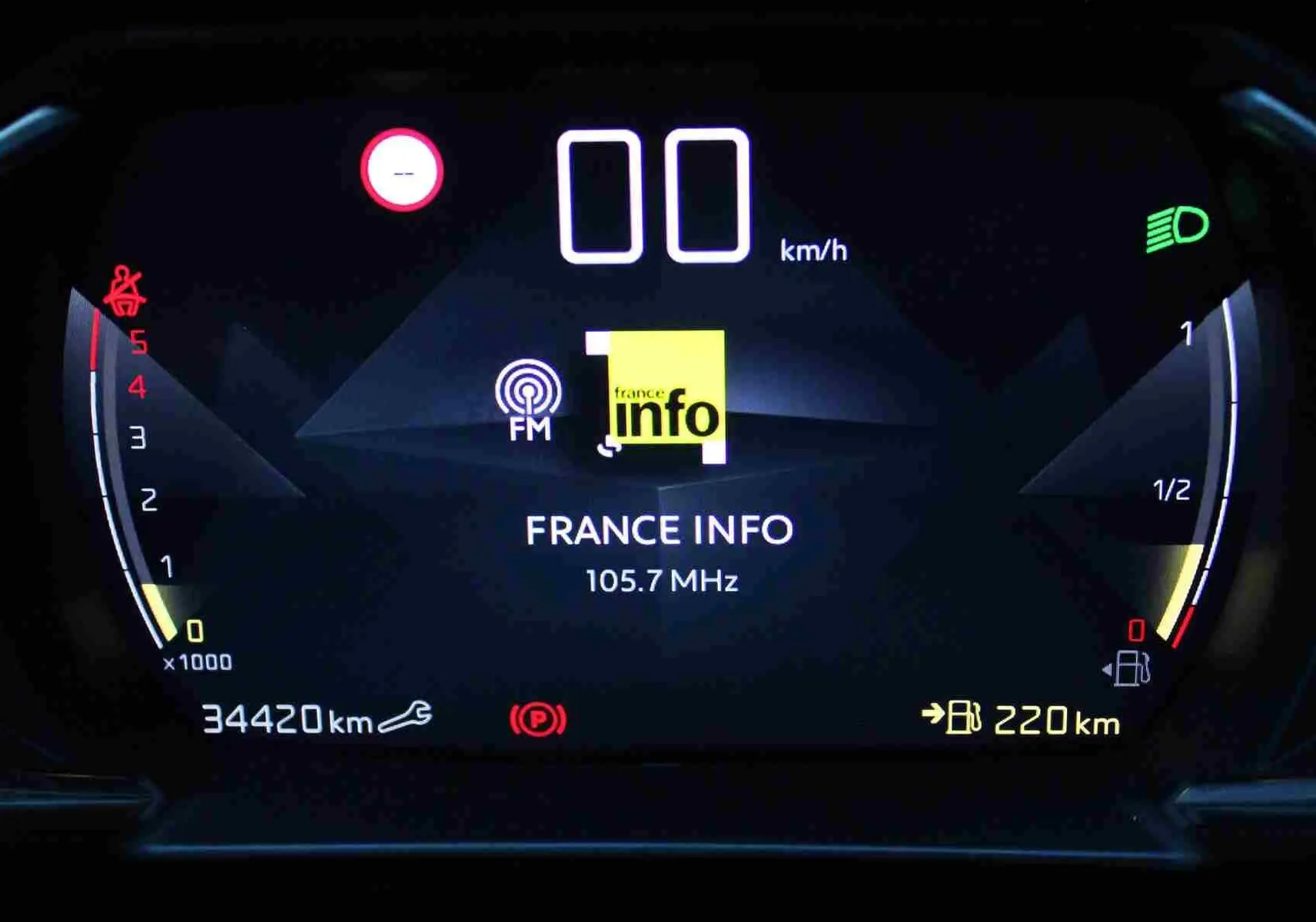 Tableau de bord numérique du DS3 Crossback gris platinium, affichant la radio France Info et la jauge de carburant.