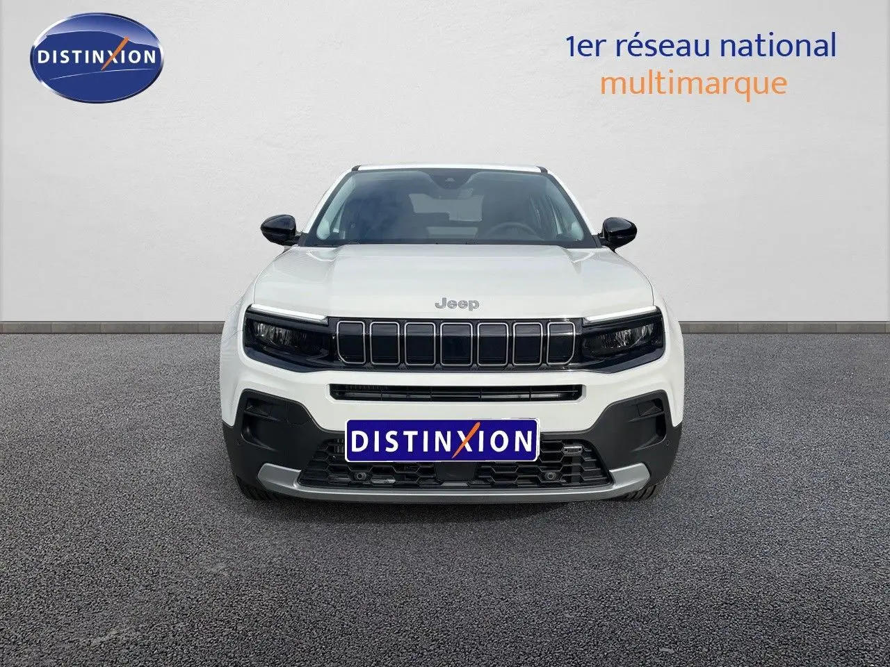 Vue frontale d'un Jeep Avenger blanc neige 2024 avec calandre noire et détails contrastés sur pare-chocs.