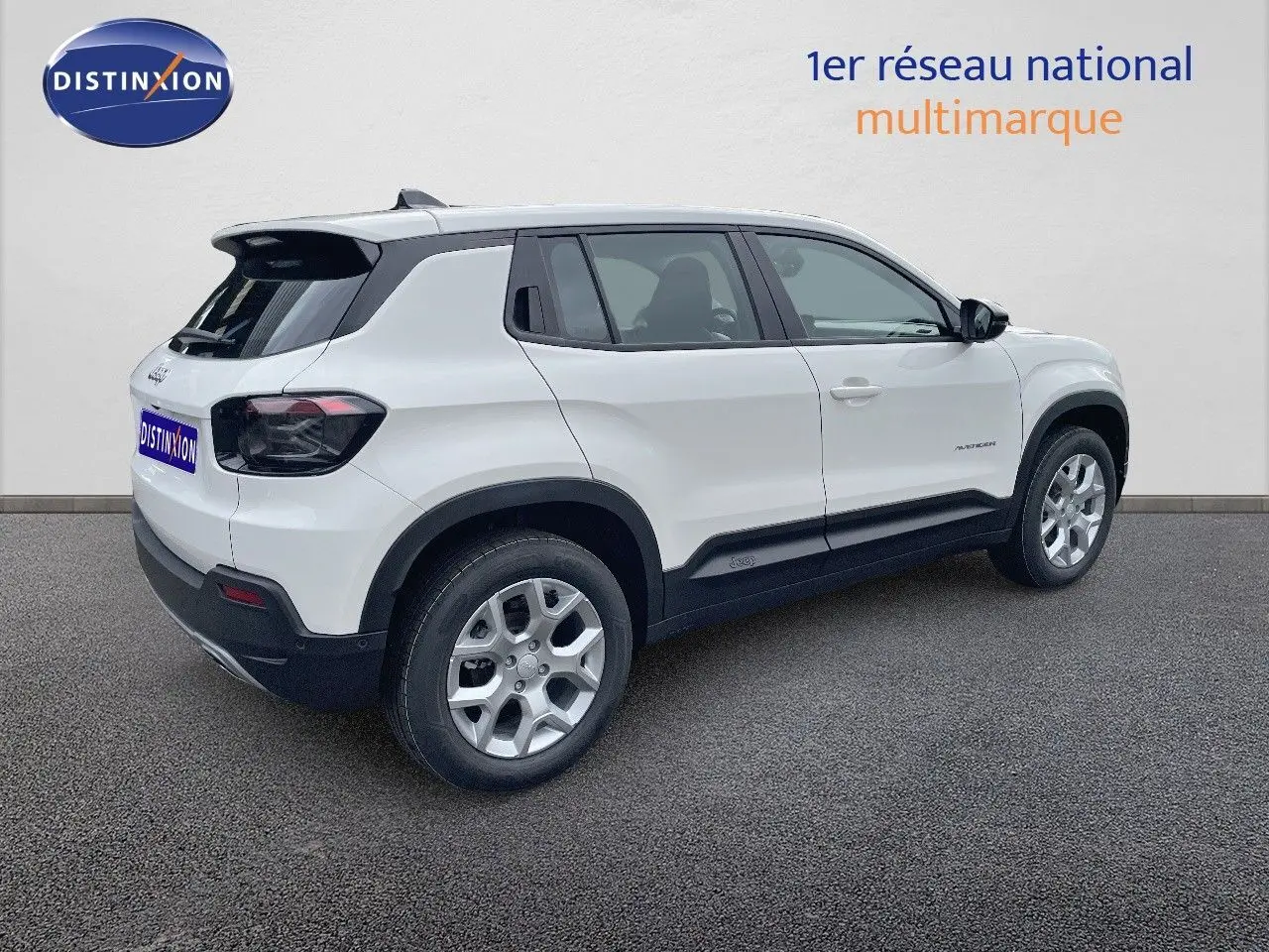 Jeep Avenger blanc neige vu de 3/4 arrière côté gauche, avec jantes argentées et feux arrière fumés.