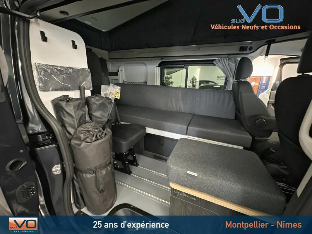 Intérieur du Renault Trafic Fourgon gris 2025, vue latérale droite montrant banquette et équipements modulables.