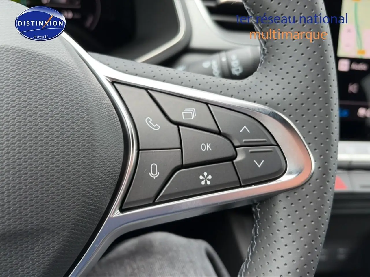 Gros plan sur les commandes multifonctions du volant perforé du Renault Captur 1.8 e-tech hybride 2026.