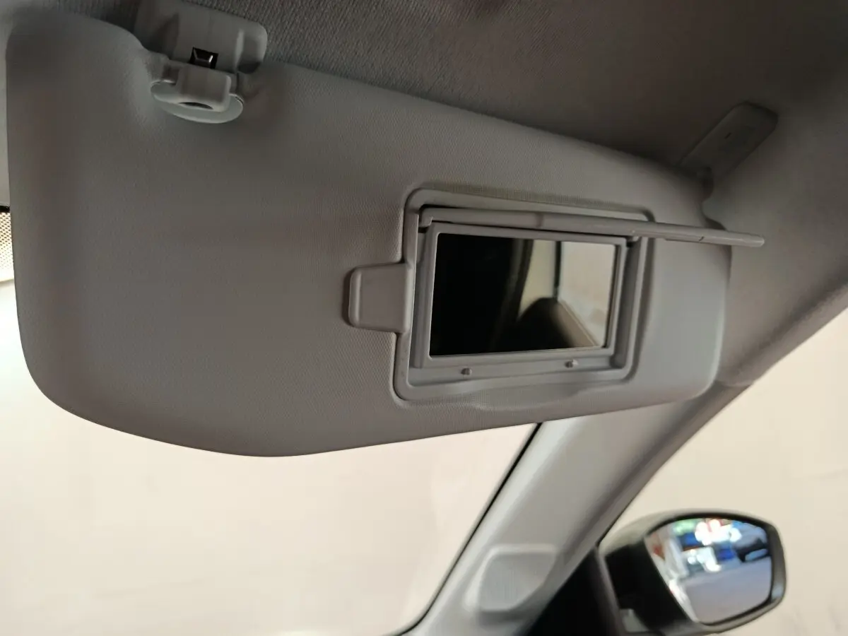 Détail du pare-soleil côté conducteur avec miroir intégré dans l'habitacle clair d'une Peugeot 208 blanche 2023.