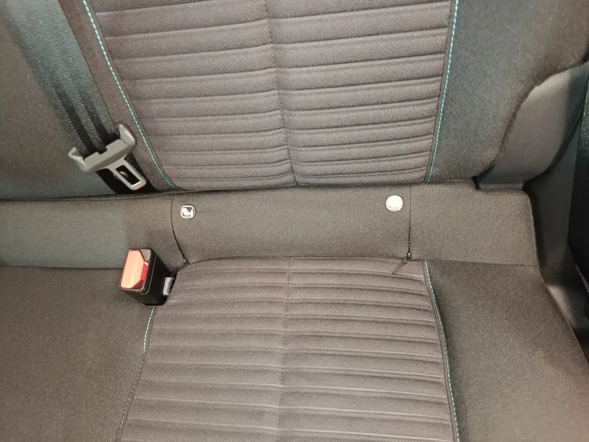 Gros plan sur la banquette arrière noire de la Peugeot 208 2023 avec surpiqûres bleues et ceinture de sécurité visible.