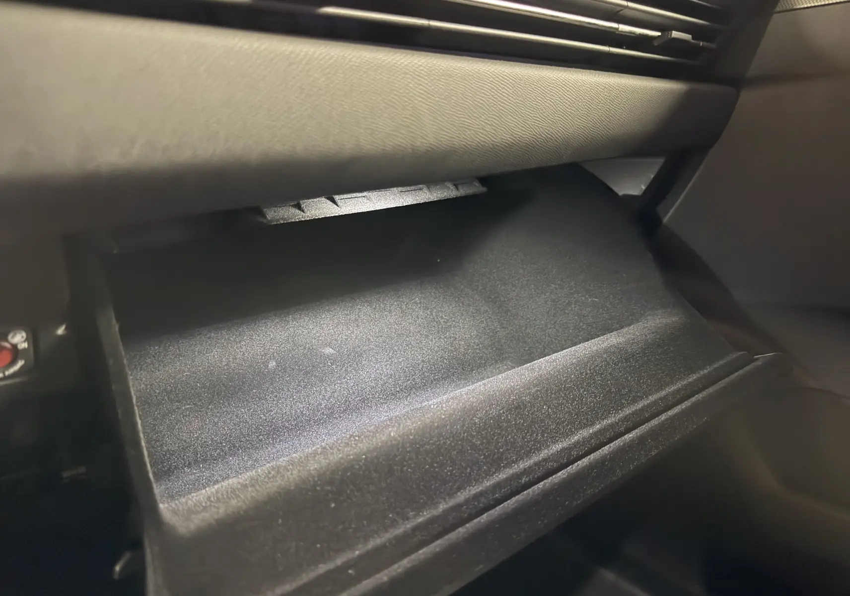 Gros plan sur la boîte à gants ouverte de l'Opel Astra 1.5D 130 BVA8 GS 2024, intérieur noir.