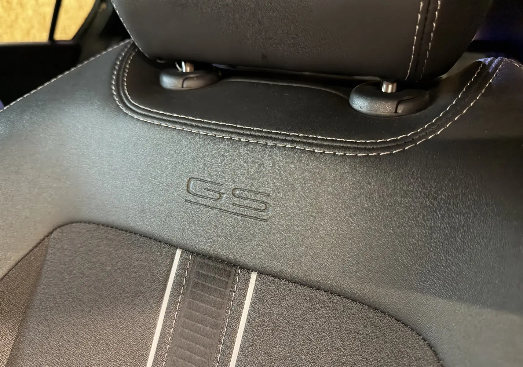 Gros plan sur le dossier de siège avant en cuir noir avec logo GS embossé dans l’habitacle de l’Opel Astra.