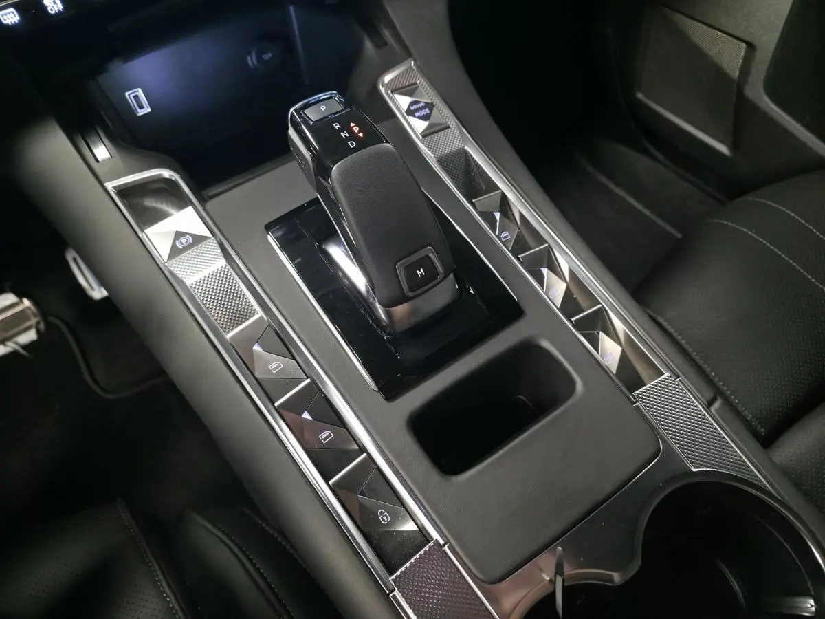 Gros plan sur la console centrale noire du DS7 Crossback 2025 avec levier de vitesse automatique et commandes tactiles.