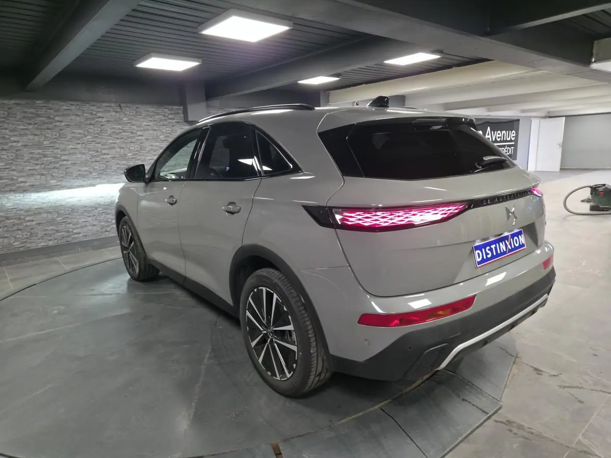 DS7 Crossback gris métallisé vu en 3/4 arrière droit, avec feux arrière LED 3D et jantes alliage noires.