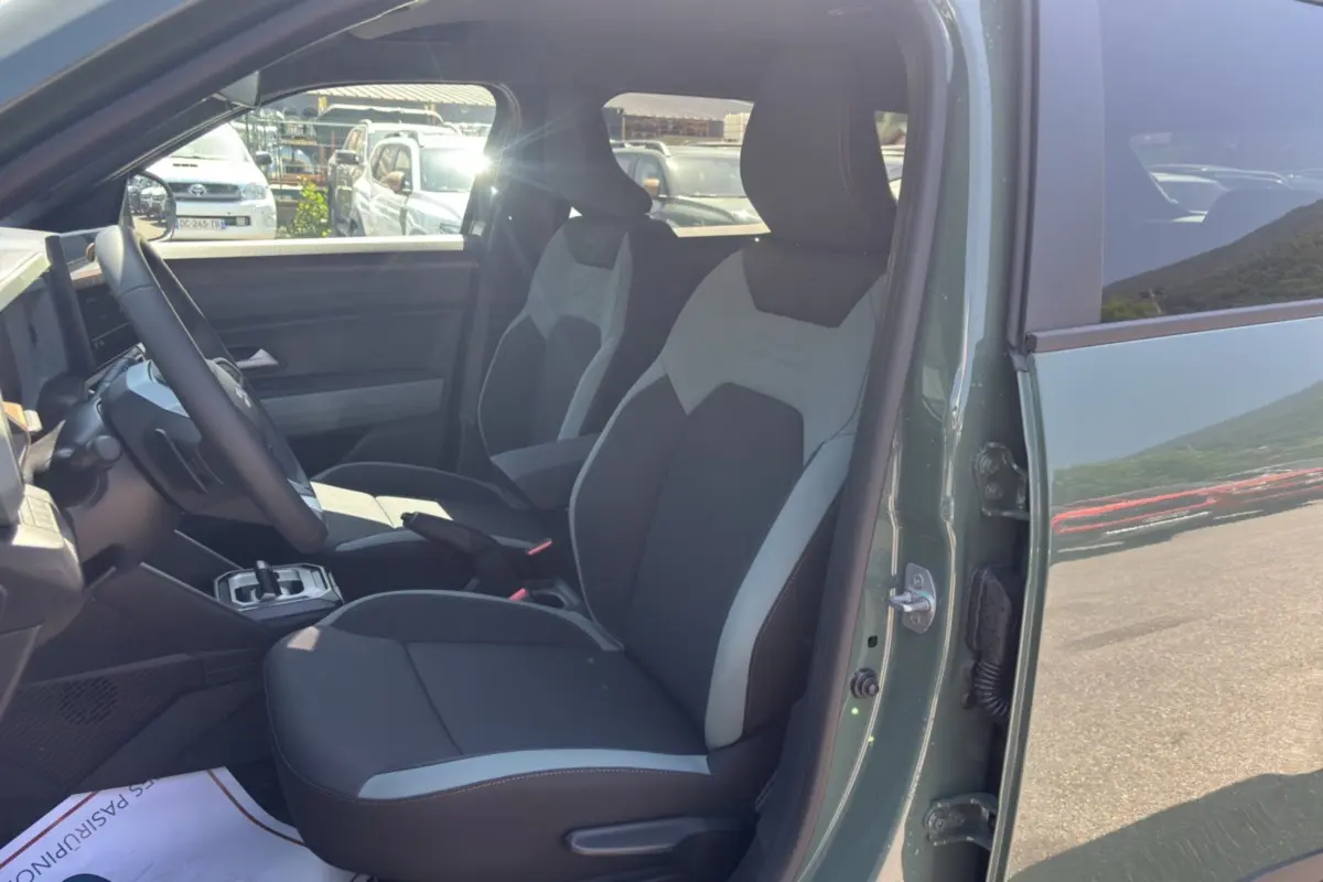 Vue intérieure côté conducteur du Dacia Duster 2026 kaki lichen, montrant les sièges avant et le volant.