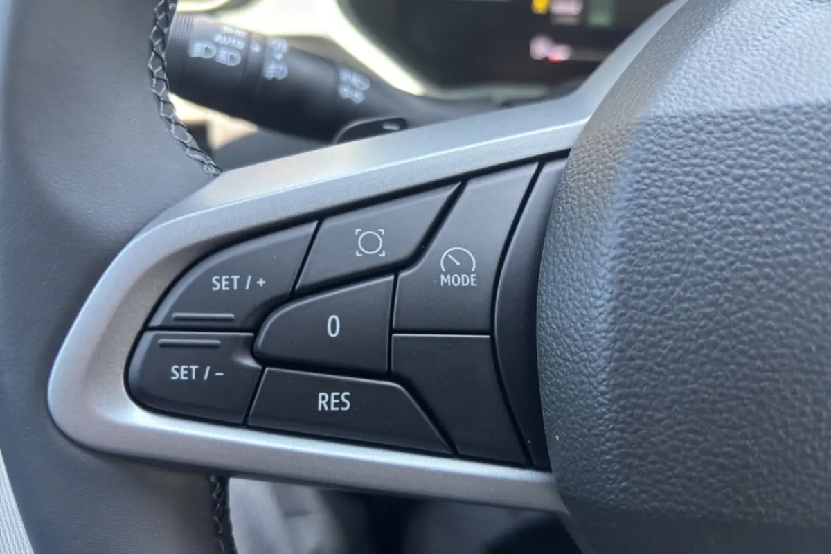 Gros plan sur les commandes de régulateur de vitesse au volant noir du Dacia Duster 2026, finition Extreme PK City.