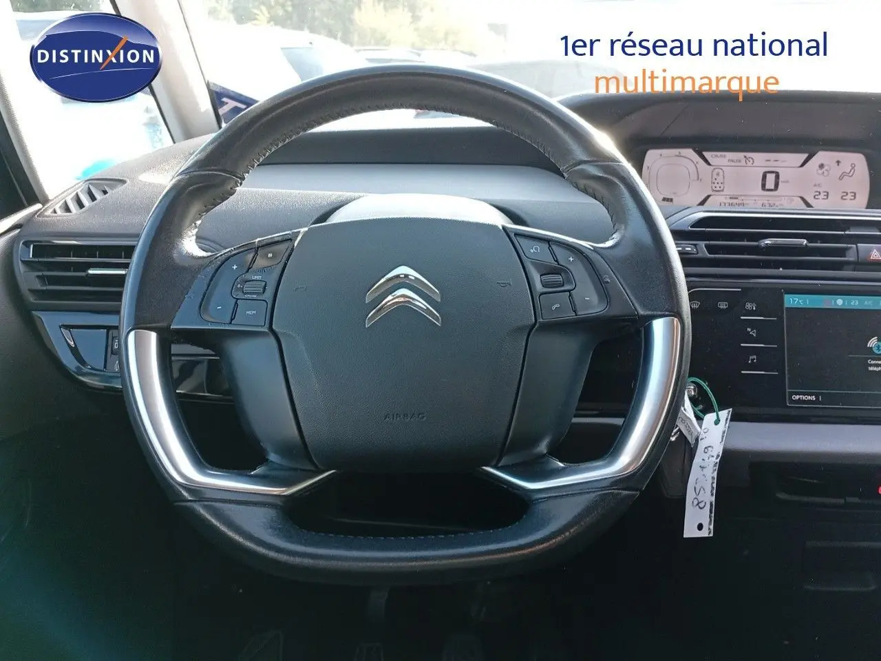 Volant cuir noir avec commandes intégrées du Citroën Grand C4 Picasso II Diesel, vue frontale de l'habitacle.