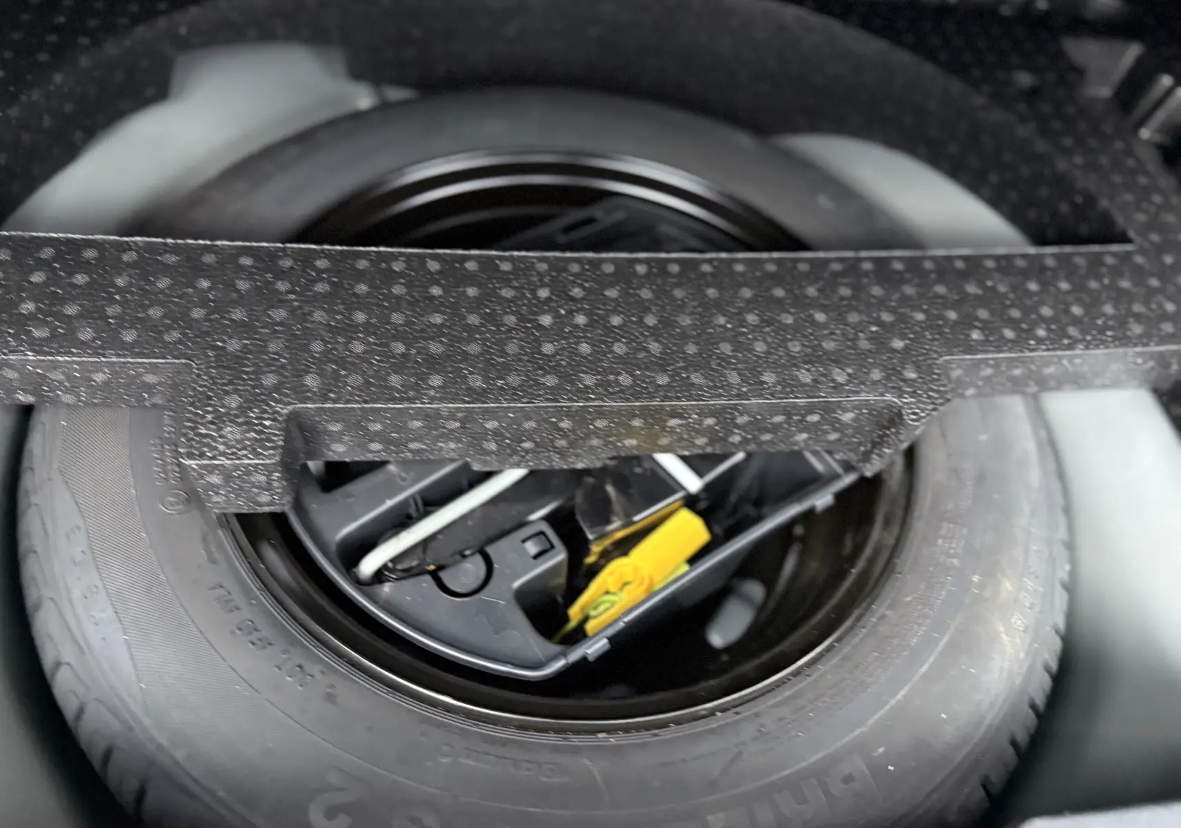 Gros plan sur la roue de secours et les outils de bord dans le coffre d’un Peugeot 2008 noir GT Line 2018.