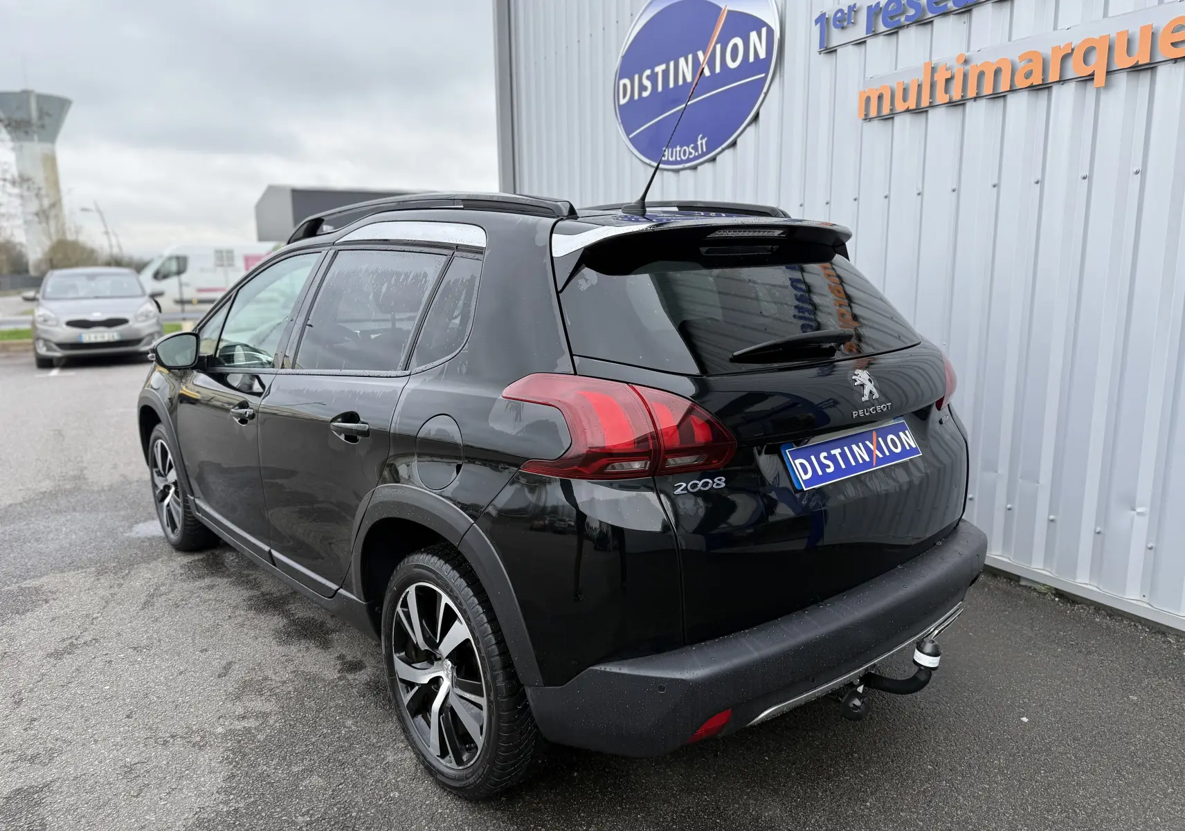 Peugeot 2008 noir 2018 vue 3/4 arrière droit, avec jantes alliage et attelage de remorque visible.