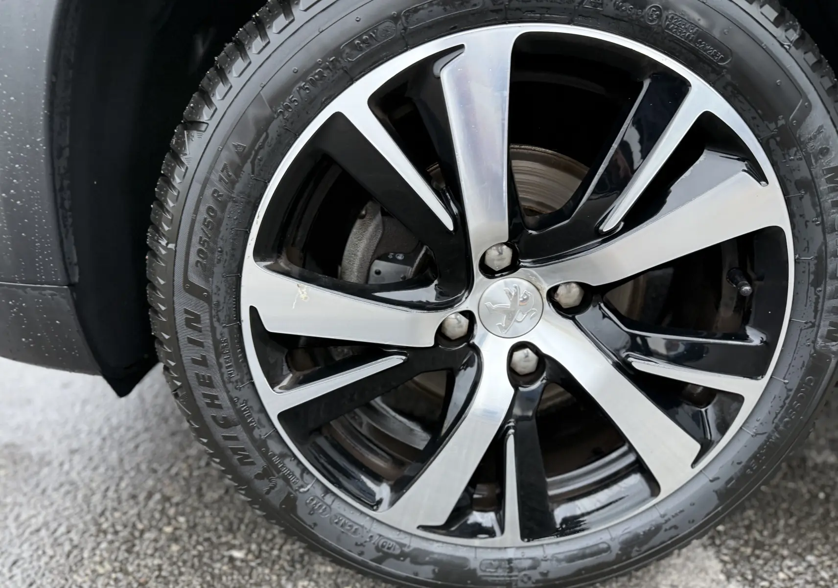 Gros plan sur la jante alliage bicolore noir et argent du PEUGEOT 2008 noir 2018, version GT LINE.