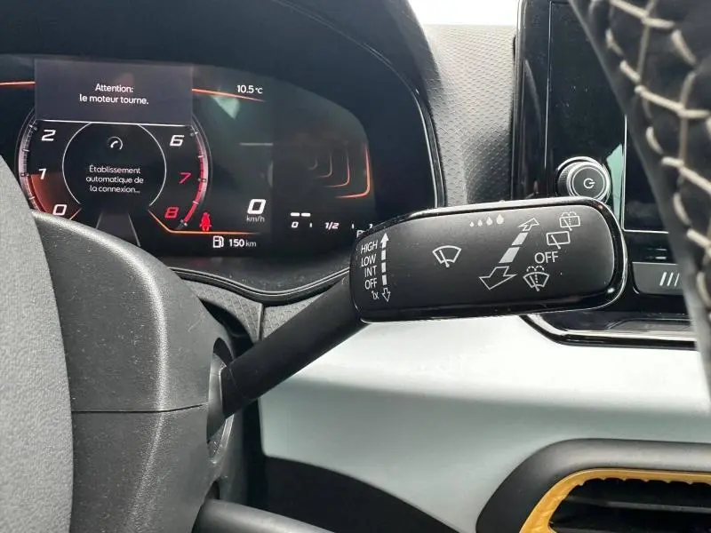 Vue rapprochée du combiné d'instruments et du commodo d'essuie-glace d'un SEAT Arona gris Magnétique Métal avec toit noir, intérieur moderne.