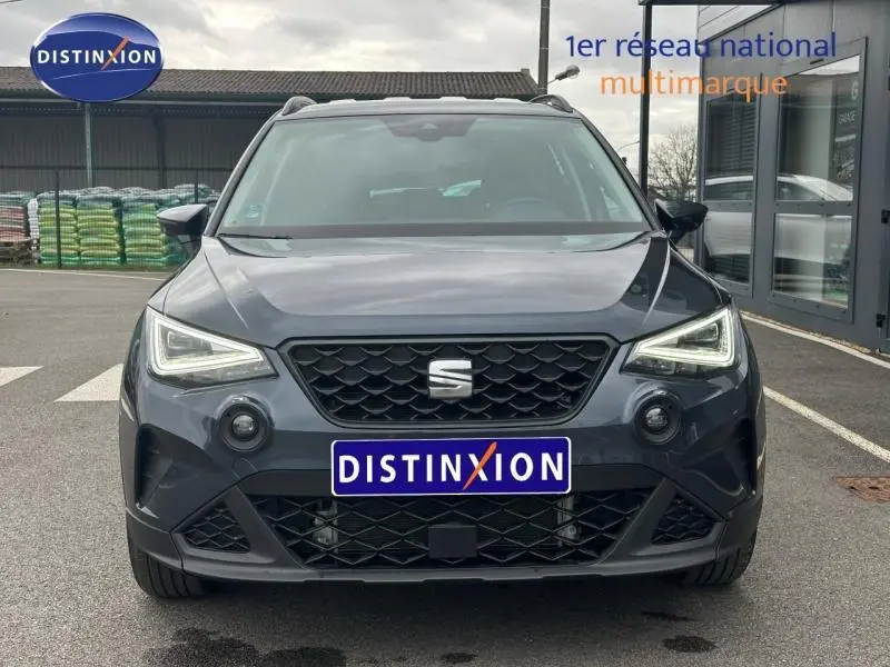 Vue frontale du SEAT Arona 1.0 TSI 115ch STYLE 2025 en gris Magnétique Métal avec toit noir, calandre et phares LED distinctifs.