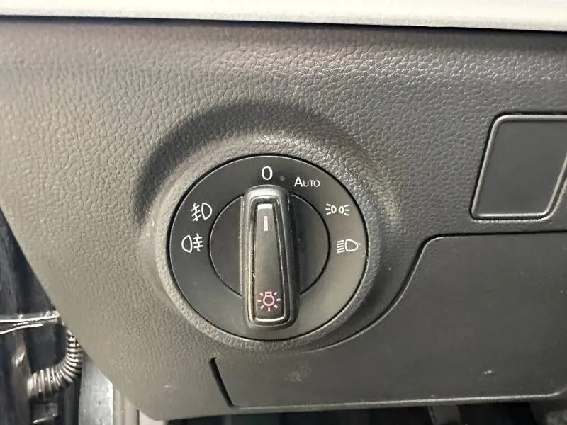 Gros plan sur le bouton de commande des phares dans l’habitacle du SEAT Arona 2025, finition Gris Magnétique Métal.