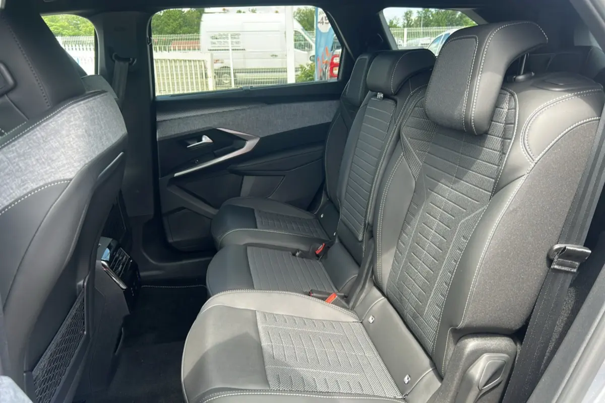 Vue latérale droite de la banquette arrière en cuir et tissu gris du Peugeot 5008 Hybrid 145 GT 7 places, intérieur spacieux.