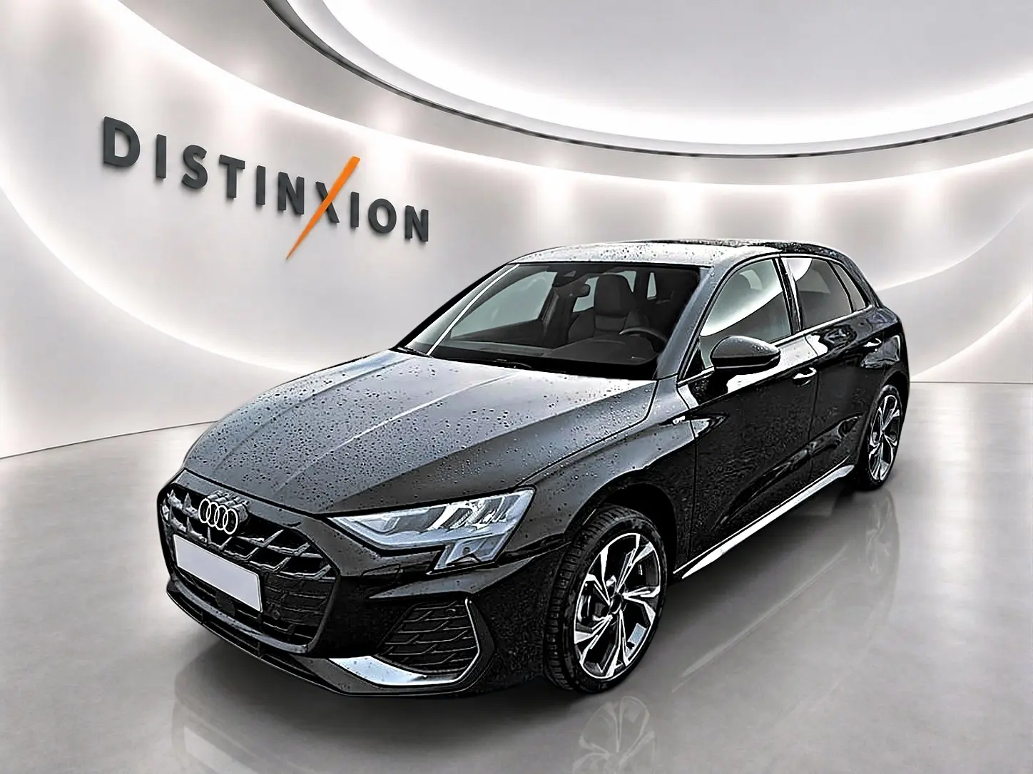 Audi A3 Sportback noir mythos vue 3/4 avant droit avec jantes alu et gouttes d'eau sur la carrosserie.