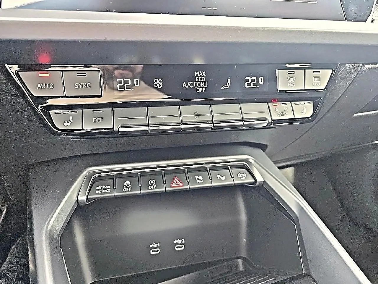 Vue rapprochée de la console centrale noire de l'Audi A3 Sportback 2026 avec commandes climatisation et boutons multifonctions.