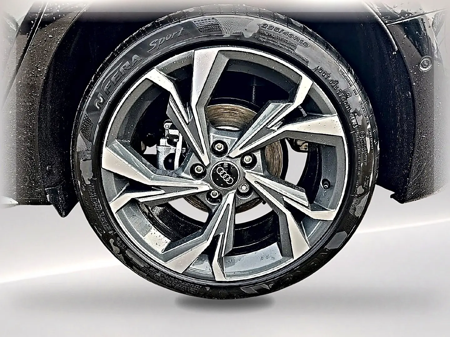 Gros plan sur la jante alu gris graphite de l'Audi A3 Sportback 2026 avec pneu N'Fera Sport humide.