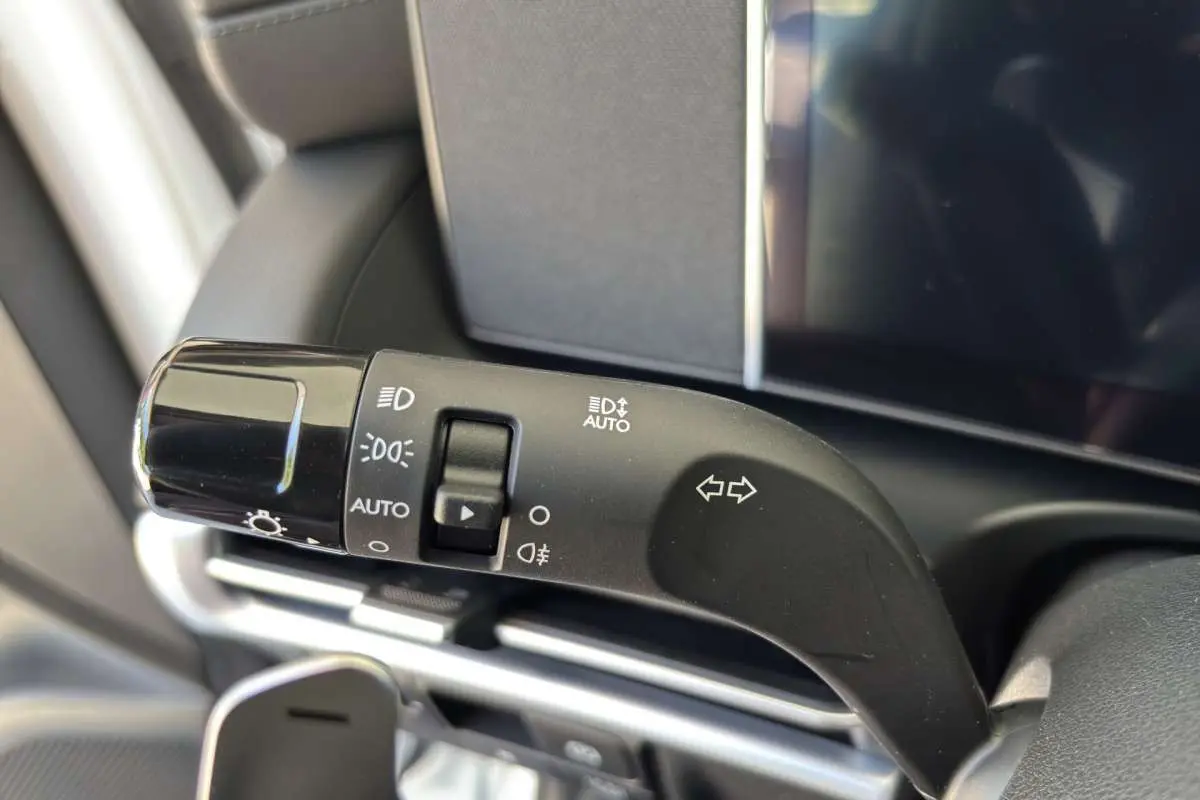 Gros plan sur la commande des feux et clignotants à gauche du volant dans un Hyundai Tucson blanc atlas 2026.