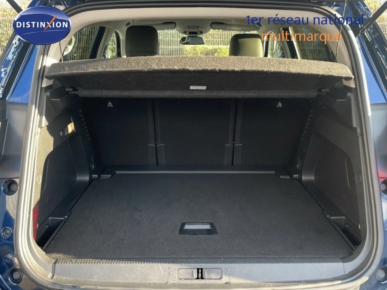 Coffre ouvert vu de l'arrière d'un Citroën C5 Aircross bleu Eclipse Métal, montrant un espace de chargement vide.