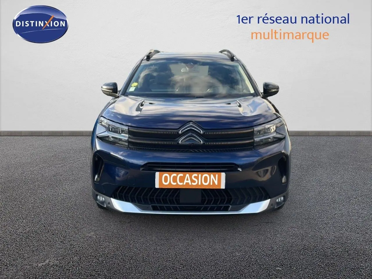 Vue frontale d'un Citroën C5 Aircross bleu Eclipse Métal avec calandre distinctive et plaque "OCCASION".
