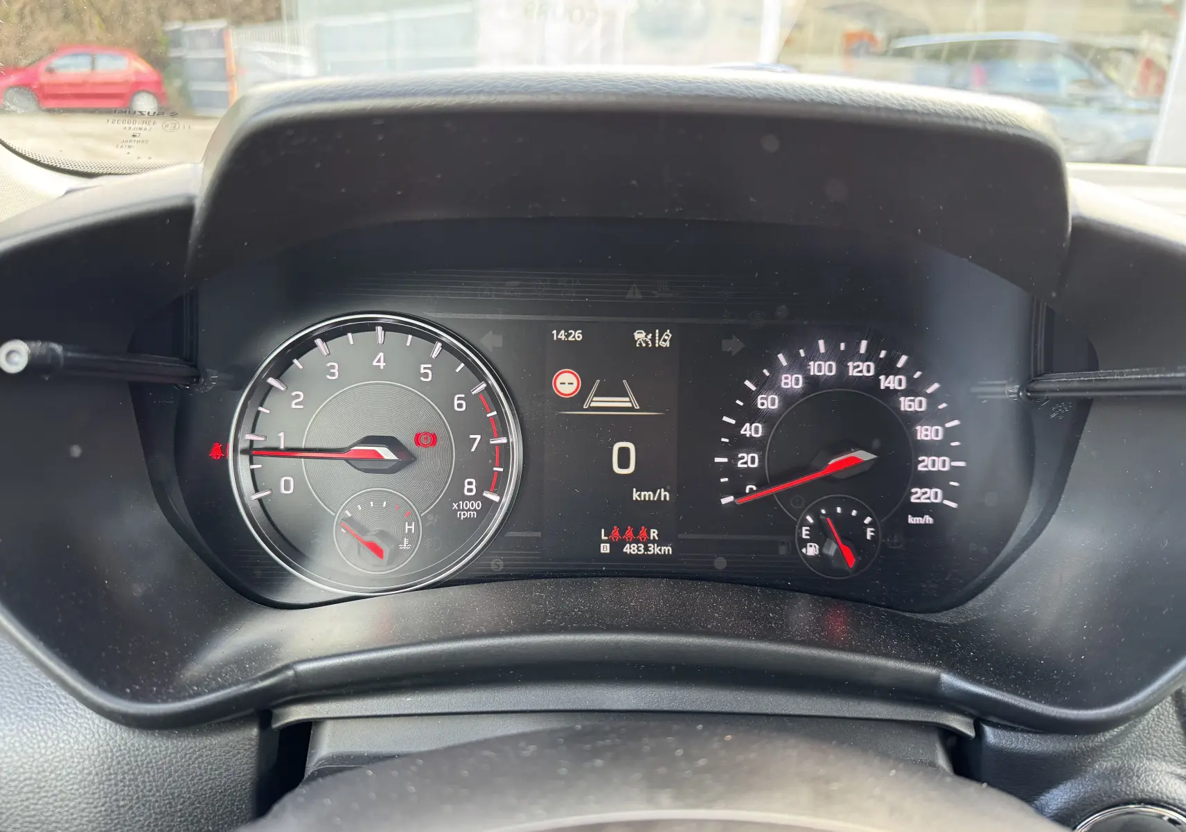 Vue rapprochée du tableau de bord de la Suzuki Swift gris, affichant le compteur de vitesse et le compte-tours numériques.