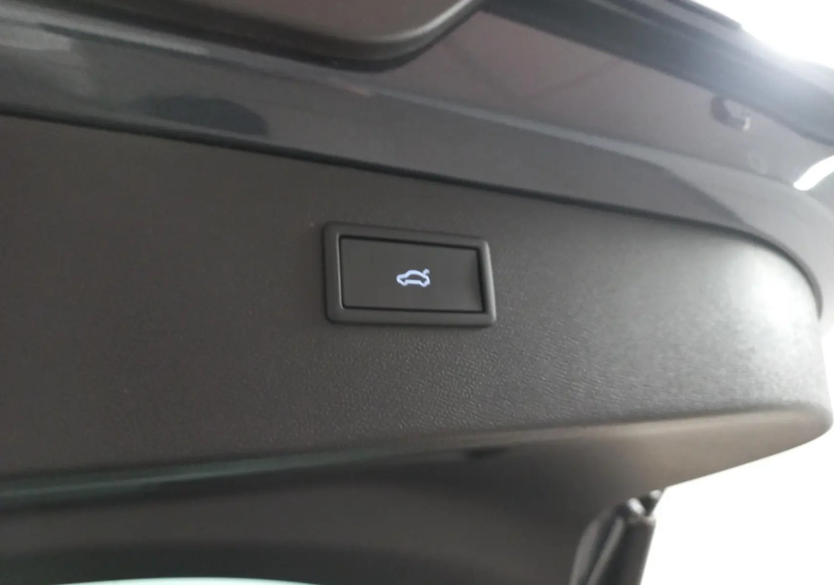 Bouton d'ouverture électrique du coffre sur la partie intérieure du hayon d'un CUPRA Formentor gris magnétique.