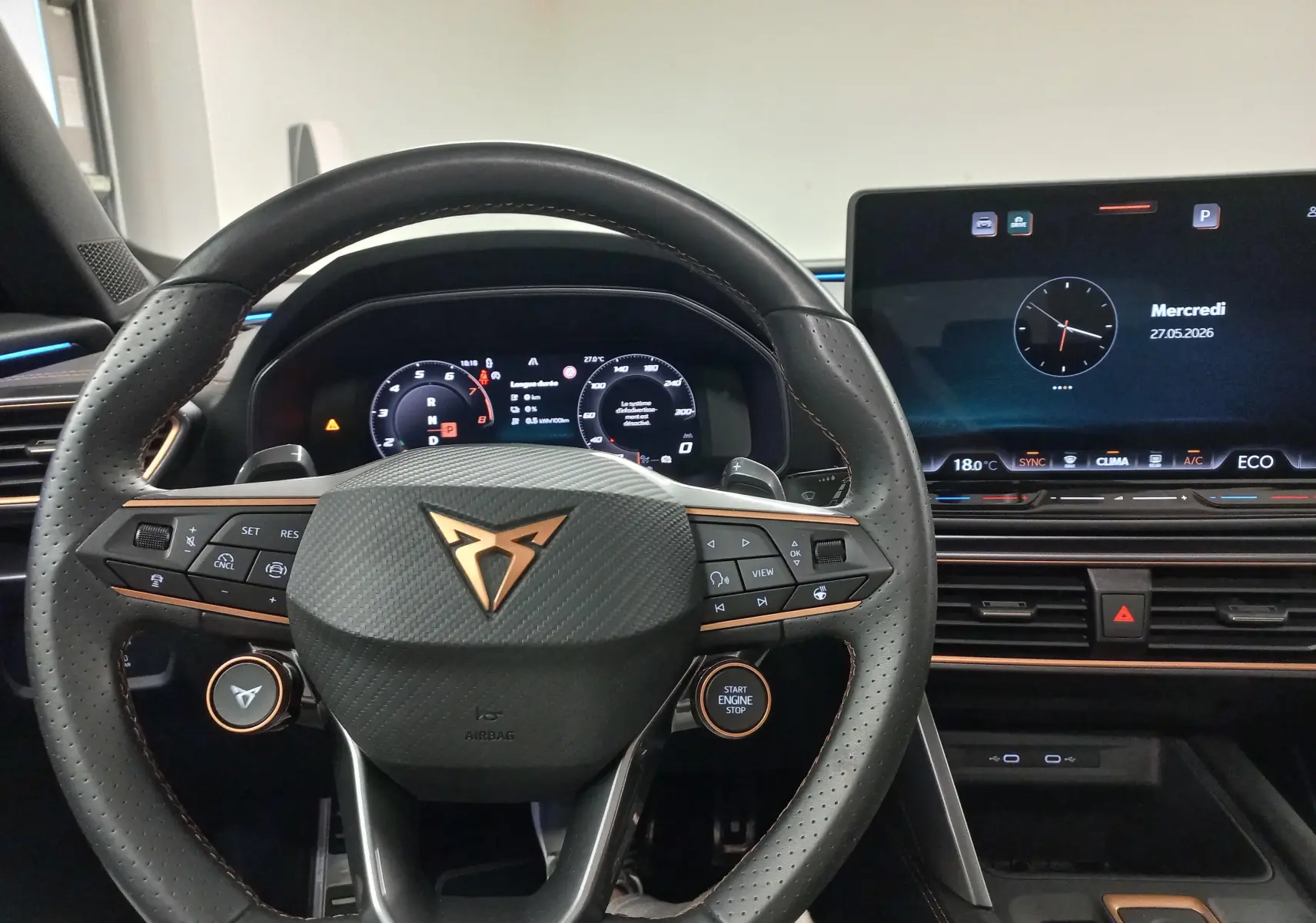 Vue intérieure centrée sur le volant et le tableau de bord numérique du CUPRA Formentor gris magnétique avec écran tactile et finitions cuivre.