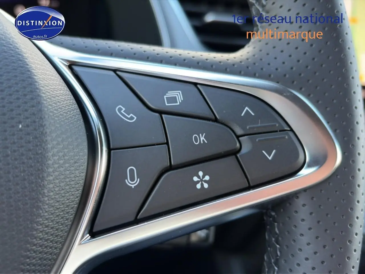 Gros plan sur les commandes multifonctions noires du volant perforé d’un Renault Captur 2026 toit noir Rafale.