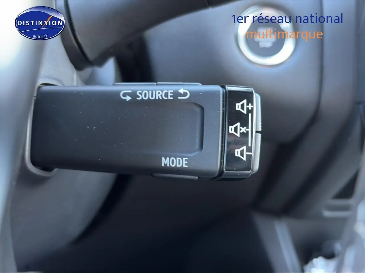 Gros plan sur la commande audio au volant du Renault Captur 1.8 e-tech hybride, intérieur noir.
