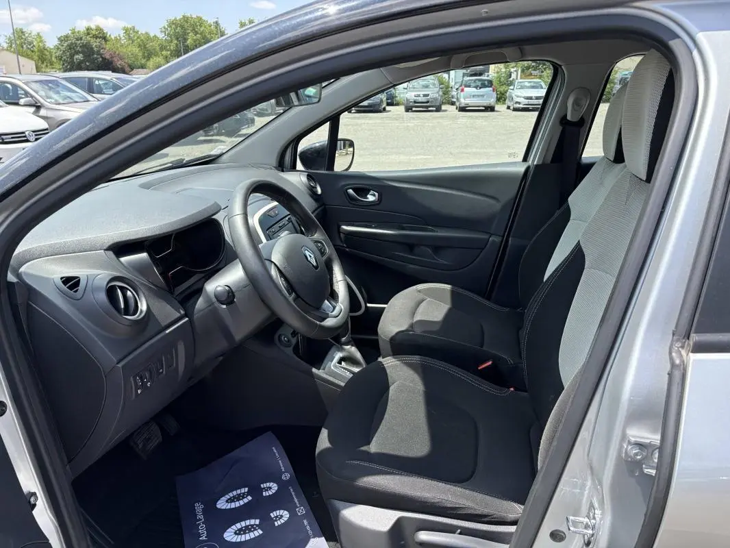 Vue intérieure côté conducteur du Renault Captur gris 2017, montrant le tableau de bord et les sièges avant.