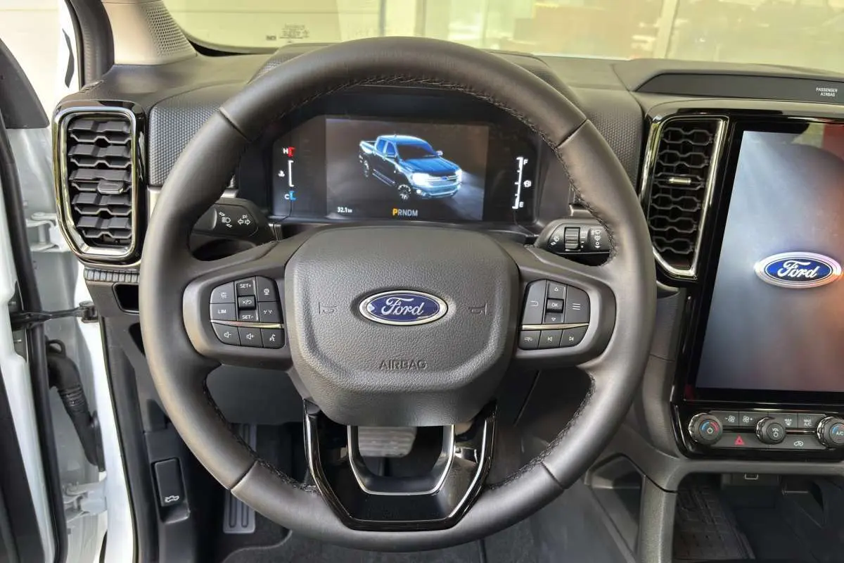 Vue centrée sur le volant du Ford Ranger blanc glacier 2026 avec tableau de bord numérique et écran tactile.