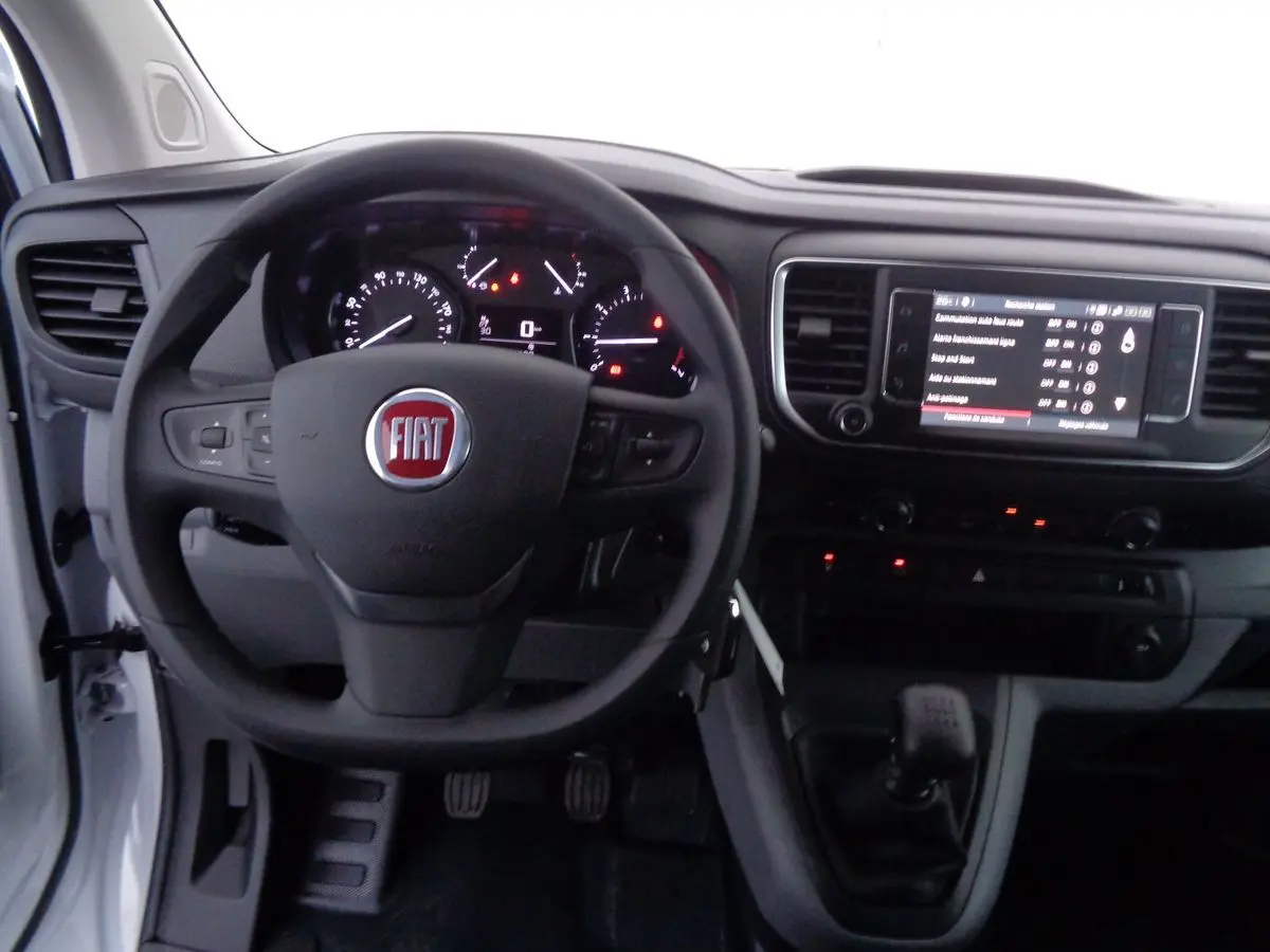 Vue intérieure du tableau de bord du Fiat Scudo Fourgon blanc, avec volant et écran tactile central allumé.