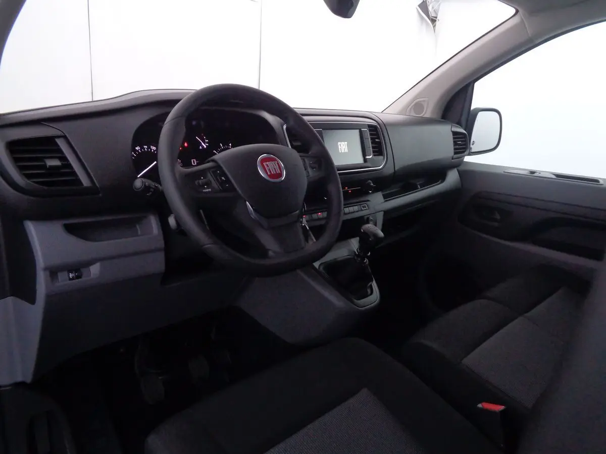 Intérieur du Fiat Scudo Fourgon 2022, vue côté conducteur sur le tableau de bord et volant noir avec écran central.