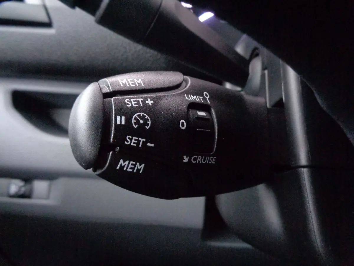 Gros plan sur la commande de régulateur de vitesse du FIAT Scudo Fourgon blanc, version 2022, intérieur noir.