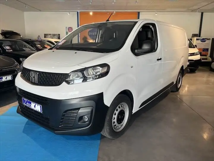 FIAT Scudo Fourgon blanc vue 3/4 avant droit en intérieur avec pare-chocs noir et jantes acier simples.