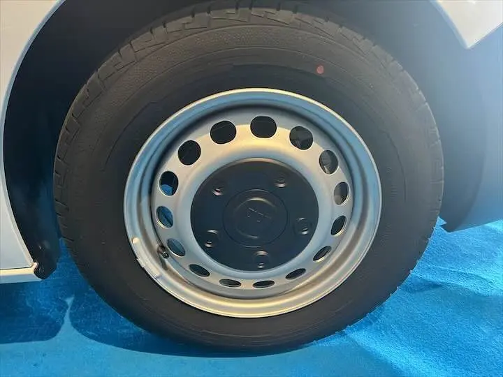 Gros plan sur la roue avant droite du FIAT Scudo Fourgon blanc, mettant en valeur la jante acier et le pneu noir.