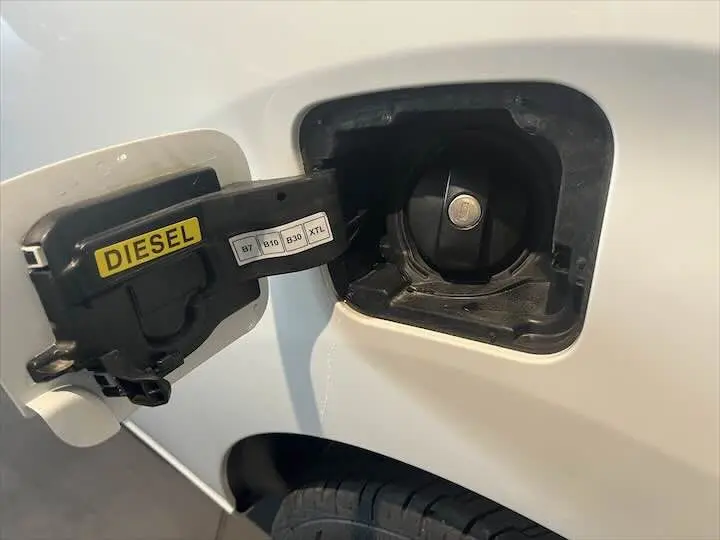 Bouchon de réservoir diesel ouvert sur le côté gauche d'un FIAT Scudo Fourgon blanc, détail du compartiment carburant.