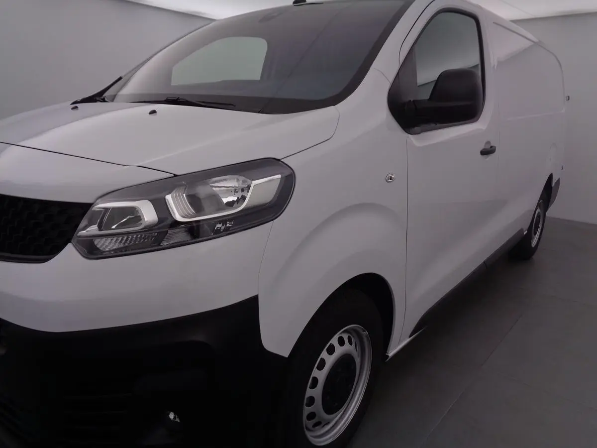 Vue 3/4 avant droit d'un FIAT Scudo Fourgon blanc avec calandre noire et jantes acier simples.