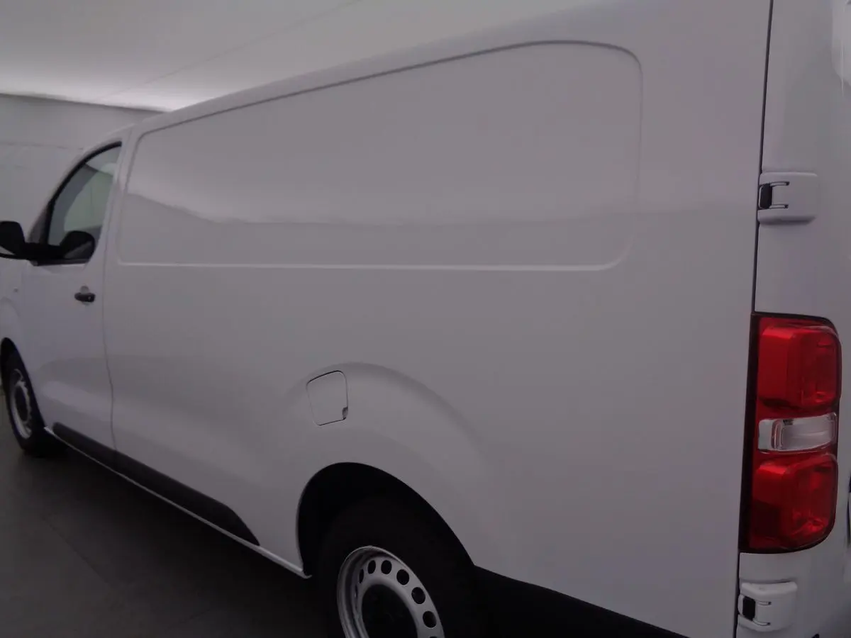 Vue latérale droite d'un fourgon FIAT Scudo blanc, mettant en valeur la carrosserie lisse et les feux arrière rouges.