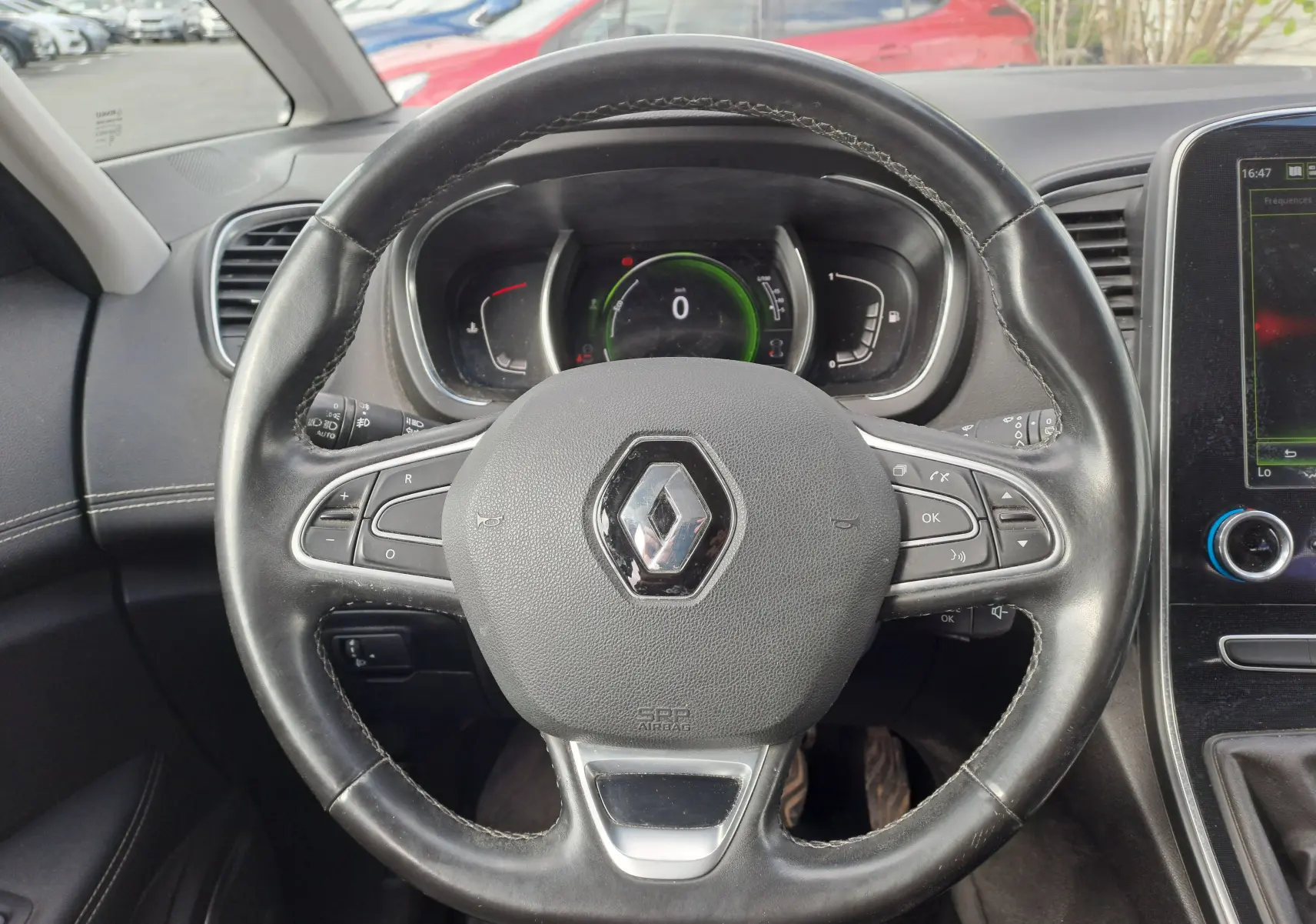 Vue rapprochée du volant en cuir noir avec logo Renault au centre du tableau de bord du Scenic IV 2018.