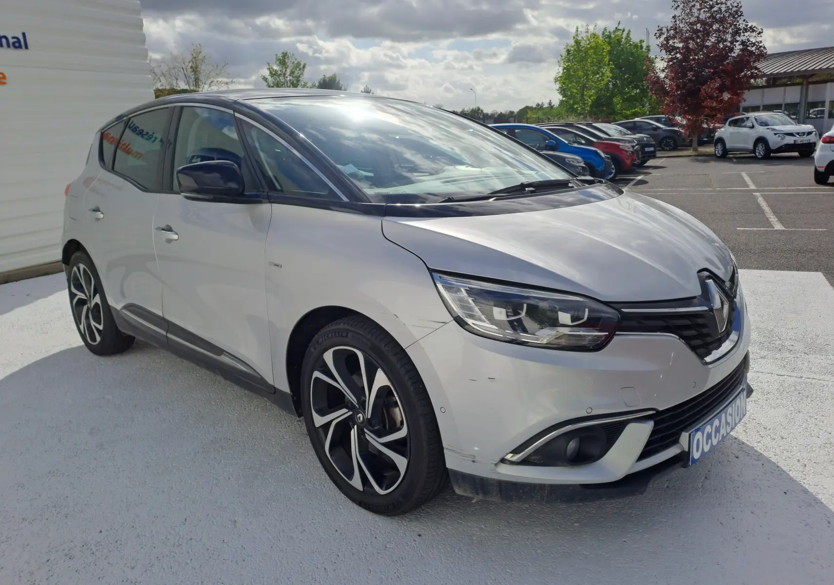 Renault Scénic IV gris platine avec toit noir, vue 3/4 avant droit, jantes alliage et calandre noire brillante.