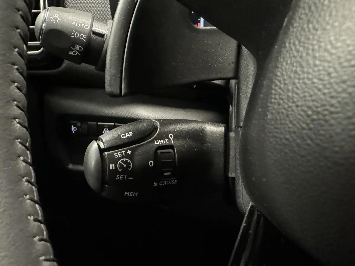 Gros plan sur la commande de régulateur de vitesse noire à gauche du volant d'un Citroën C5 Aircross 2022.